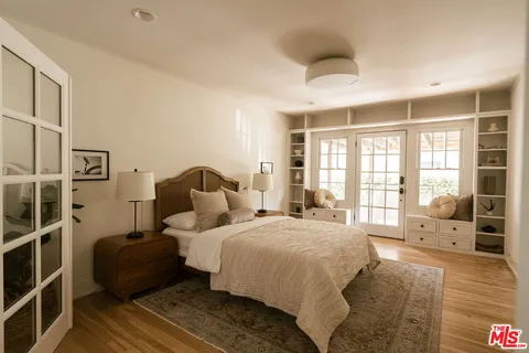 a bedroom with a bed lamp and large window