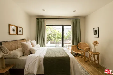 a bedroom with a bed and a large window