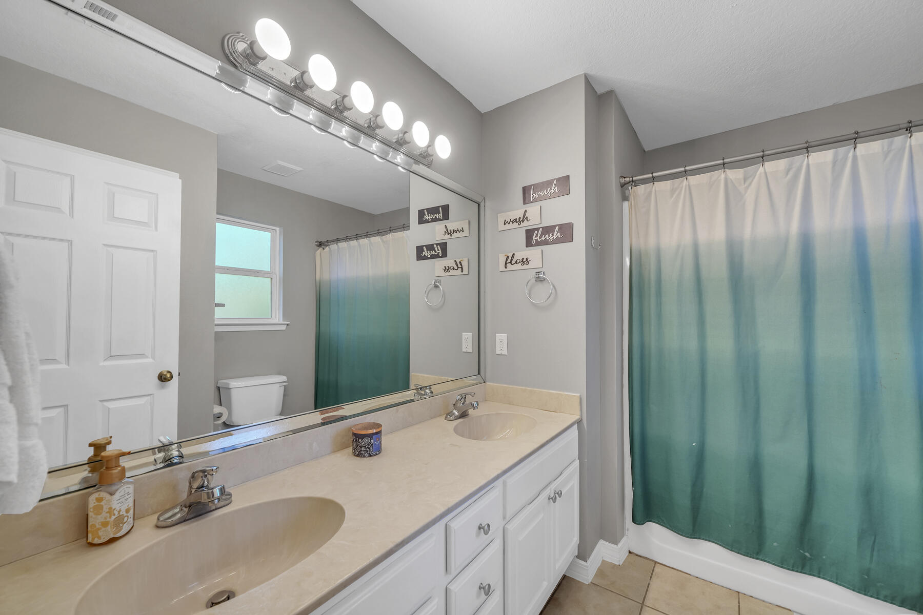 1705 North Pearl Street Crestview, FL 32536 - Photo 13 of 23 a bathroom with a double vanity sink and a mirror