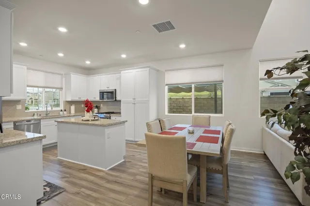 a kitchen with stainless steel appliances kitchen island granite countertop a sink and chairs
