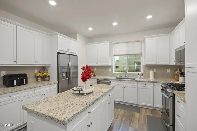 a kitchen that has a lot of cabinets in it and wooden floors