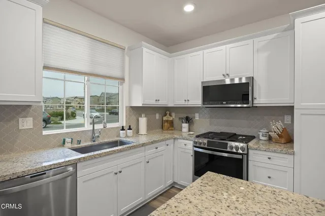 a kitchen with a sink stove top oven and cabinets