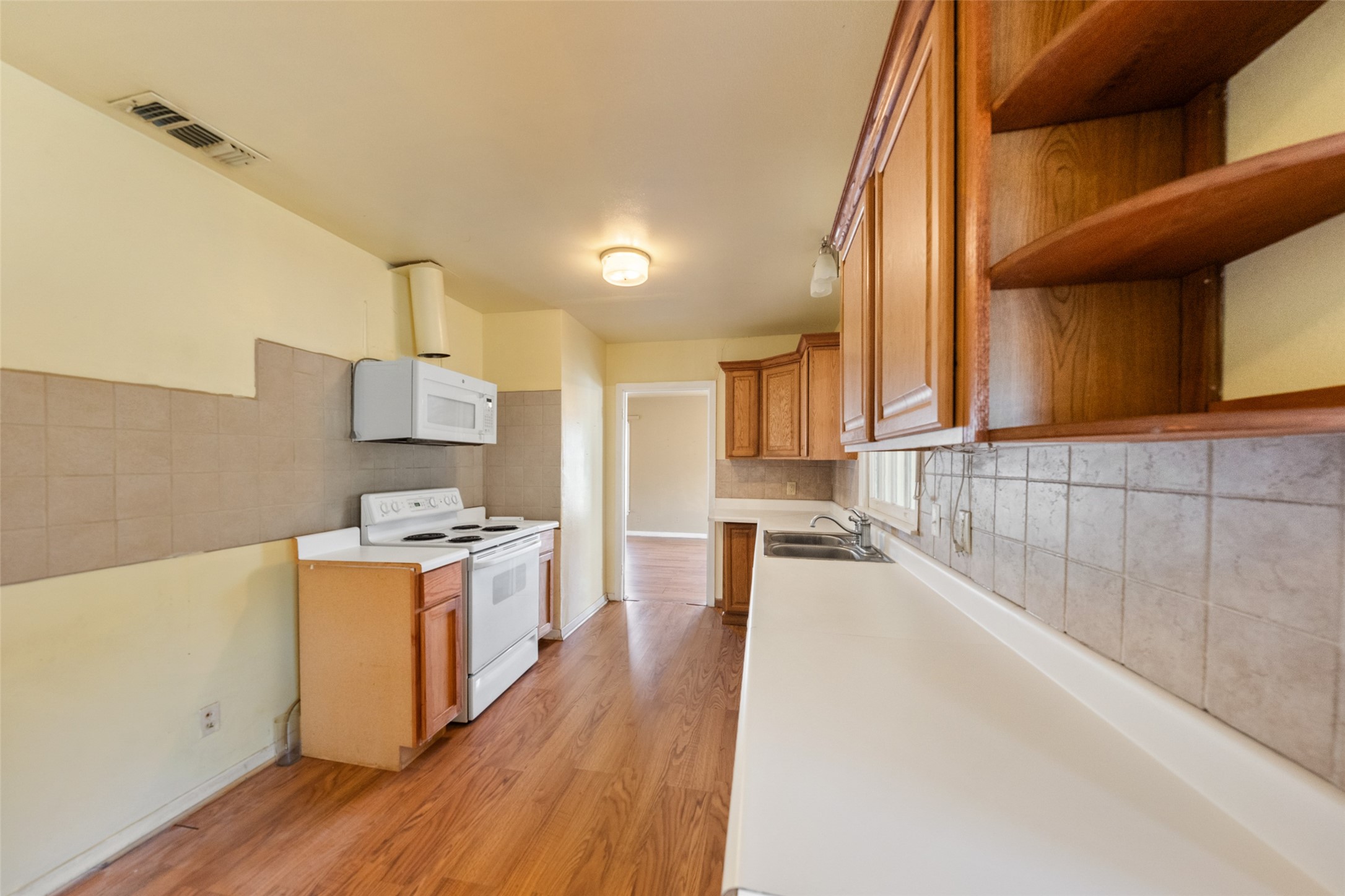 810 Main Street Hempstead, TX 77445 - Photo 14 of 32 Additional kitchen perspective showcasing extensive cabinetry, counter space, and direct connection to the adjoining living areas.