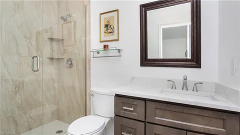 a bathroom with a toilet sink vanity and shower