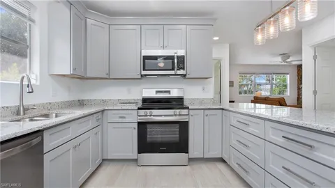 a kitchen with white cabinets stainless steel appliances and sink