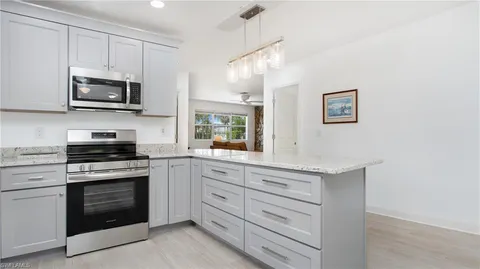 a kitchen with stainless steel appliances granite countertop white cabinets a stove top oven a sink and dishwasher