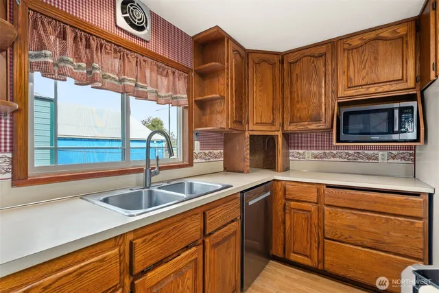 a kitchen with stainless steel appliances granite countertop a sink and a microwave