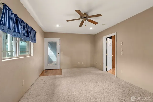 a view of a livingroom with a ceiling fan and window
