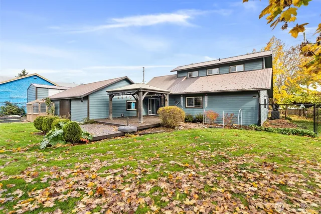 a view of a house with a big yard and large trees