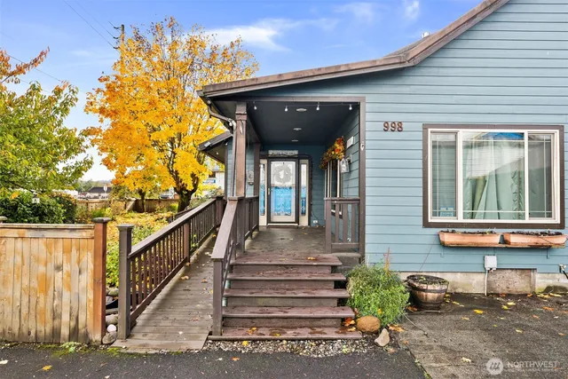 a view of a house with large windows and flower plants