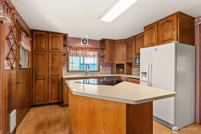a kitchen with stainless steel appliances granite countertop a refrigerator a stove and a sink