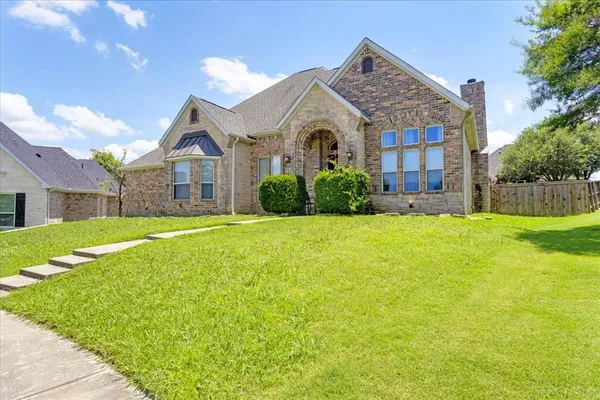 a front view of a house with yard and green space
