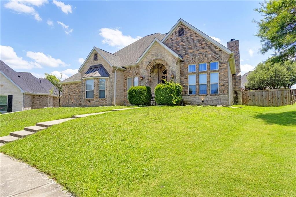 a front view of a house with yard and green space