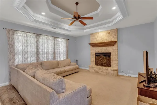 a living room with furniture a fireplace and kitchen view