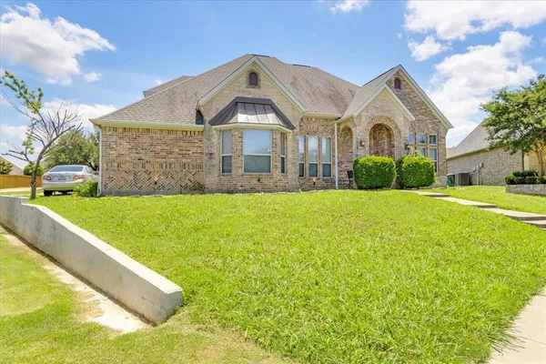 a front view of a house with yard and green space