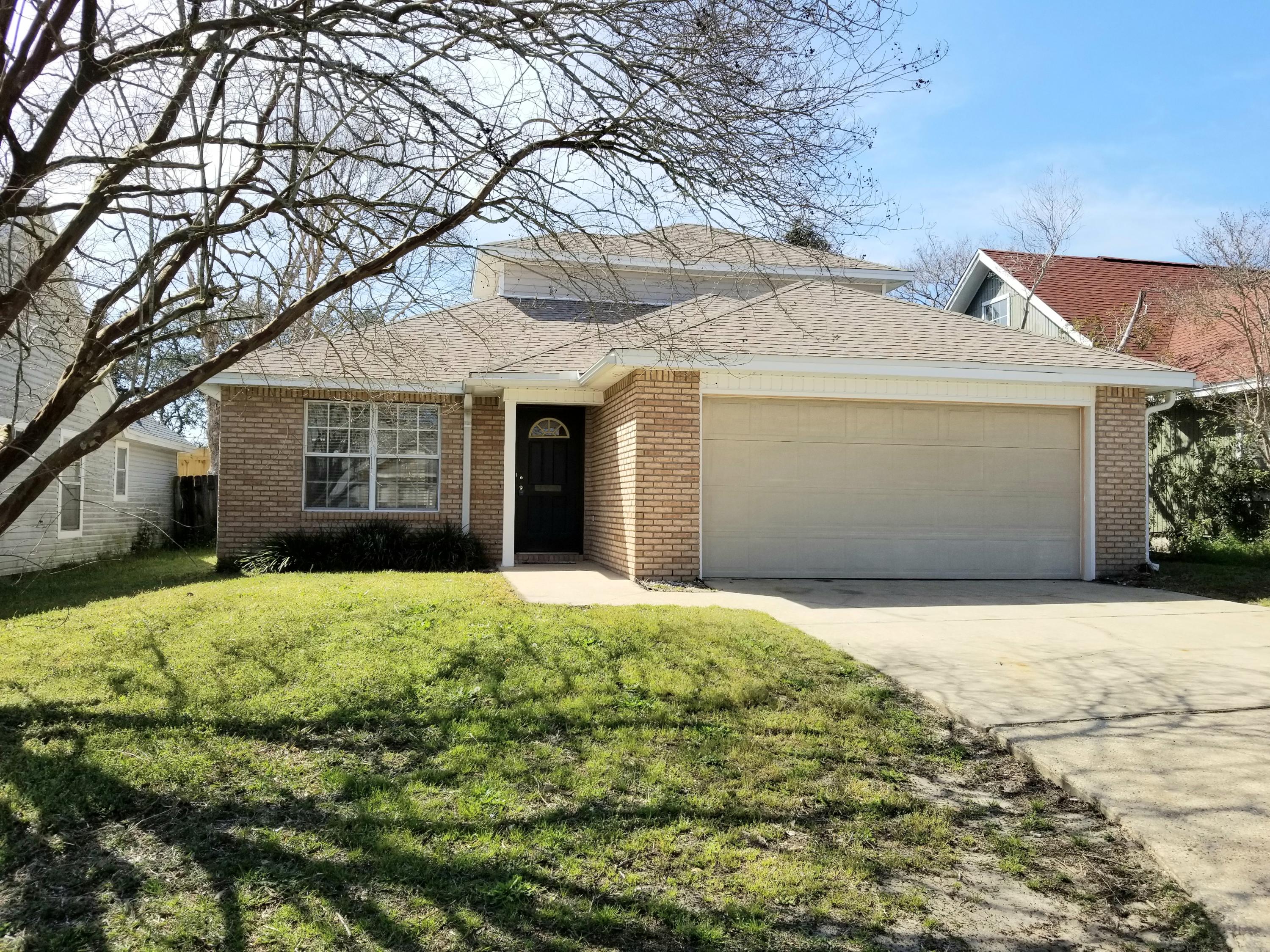 307 Rue Dianne Mary Esther, FL 32569 - Photo 1 of 17 a front view of a house with a yard and garage