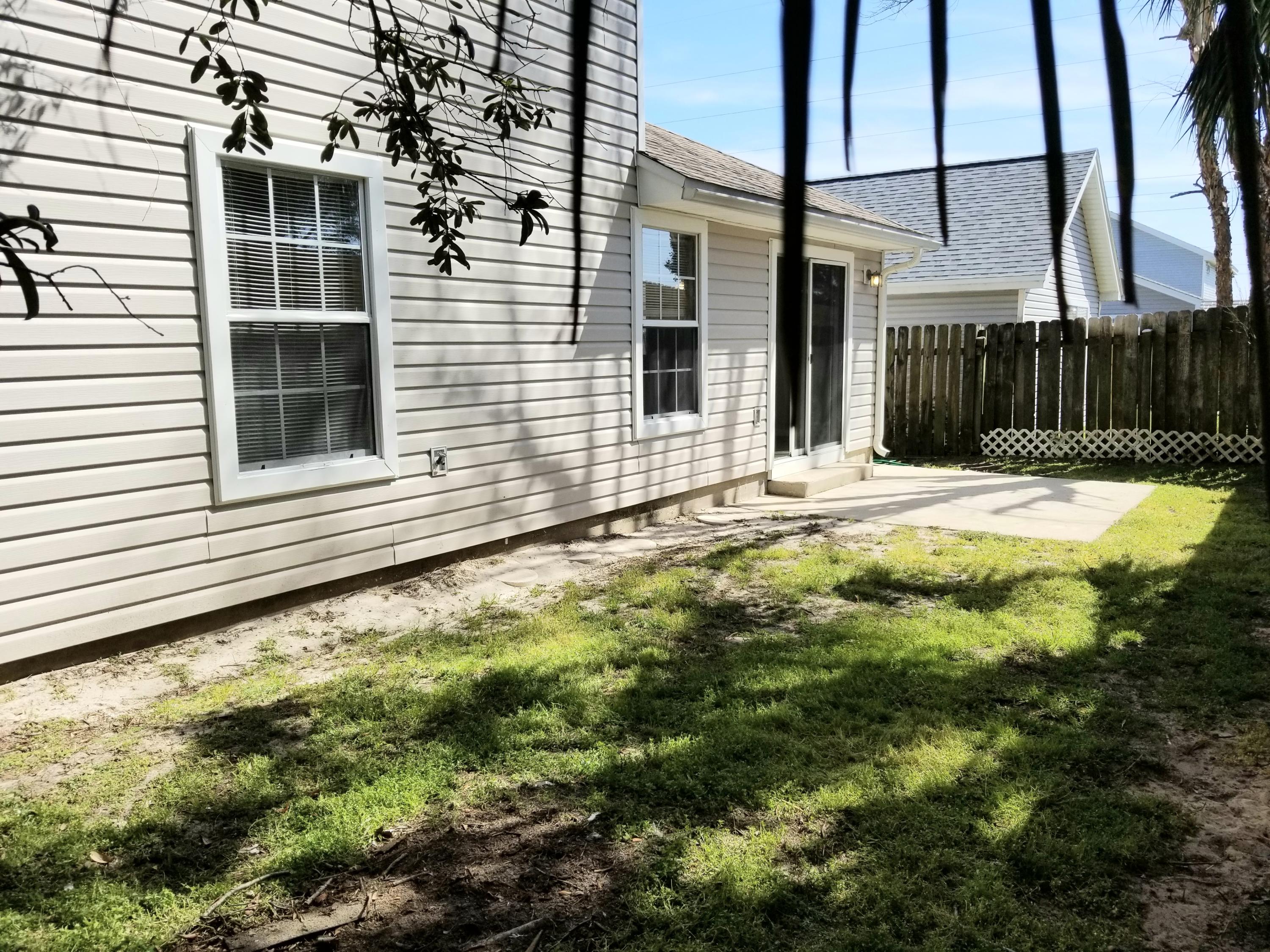 307 Rue Dianne Mary Esther, FL 32569 - Photo 15 of 17 a view of a backyard with table and chairs and wooden fence