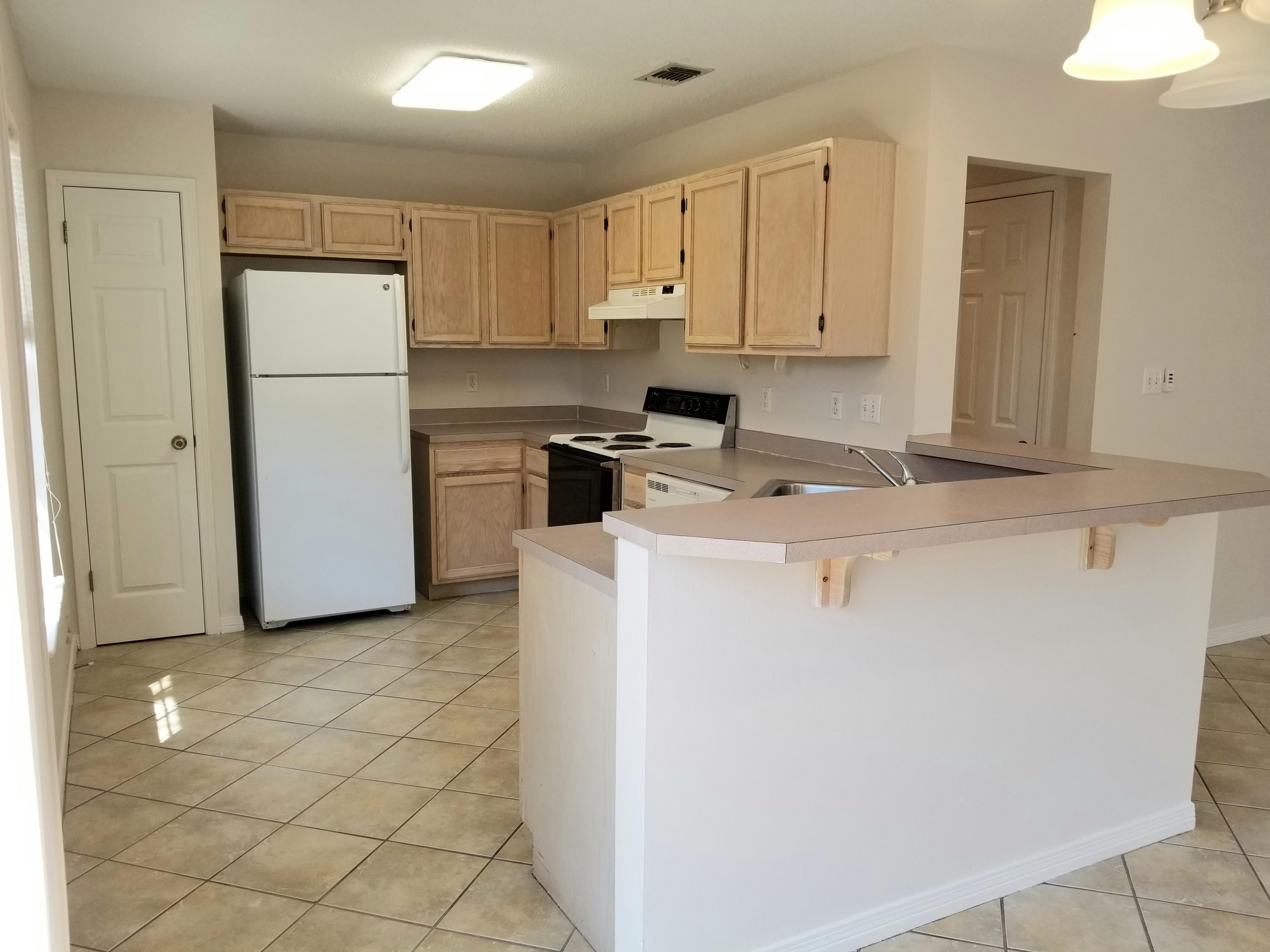 307 Rue Dianne Mary Esther, FL 32569 - Photo 3 of 17 a kitchen with a refrigerator sink stove and cabinets