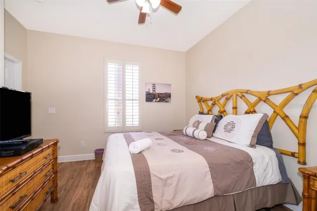 a bedroom with a bed and a flat tv screen on dresser