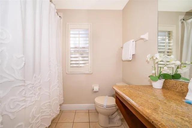 a bathroom with a granite countertop sink a toilet and shower