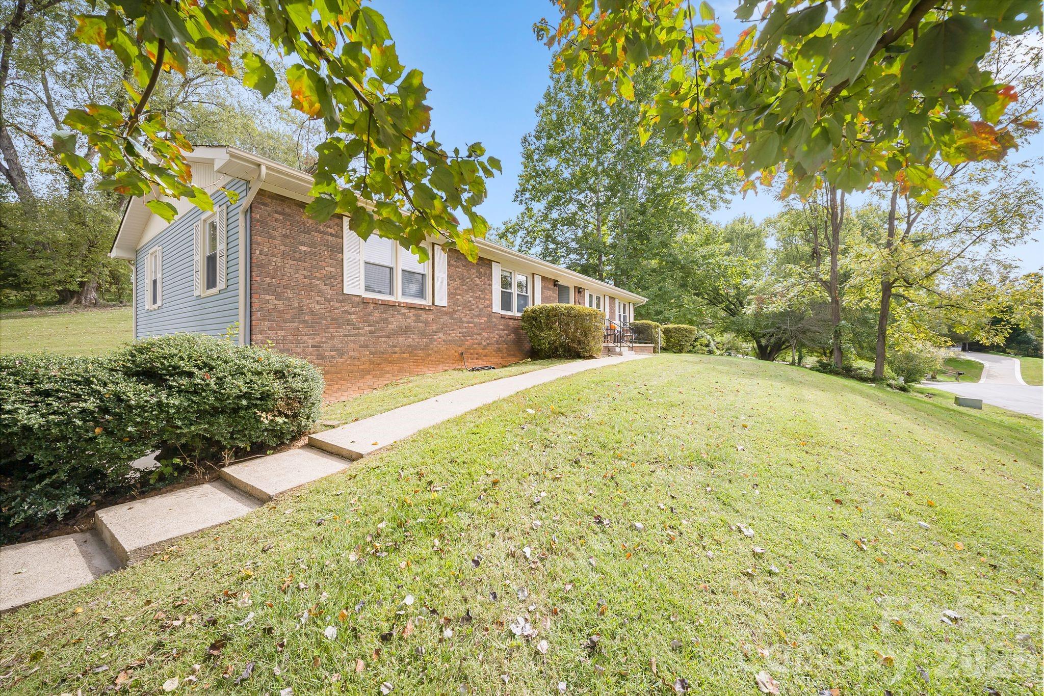16 Sun Valley Court Alexander, NC 28701 - Photo 36 of 47 a yellow house with trees in front of it