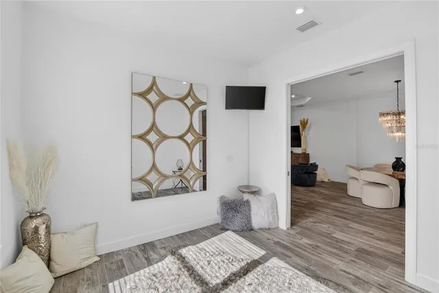 a kitchen with stainless steel appliances granite countertop a kitchen island a stove a refrigerator a dining table and chairs with wooden floor