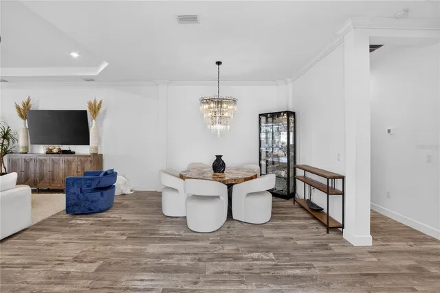 a living room with furniture kitchen view and a chandelier
