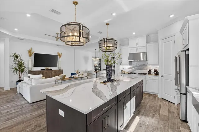a living room with furniture a ceiling fan and a large window
