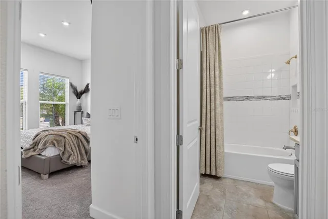 a bathroom with a granite countertop sink a toilet a mirror a bathtub and shower