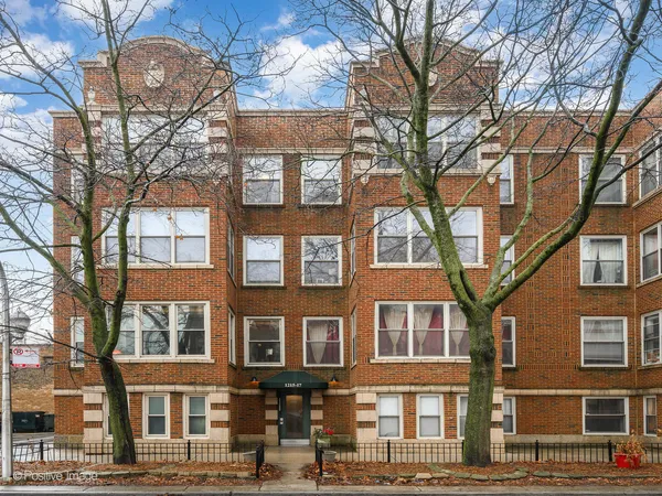 a front view of a residential apartment building with a yard