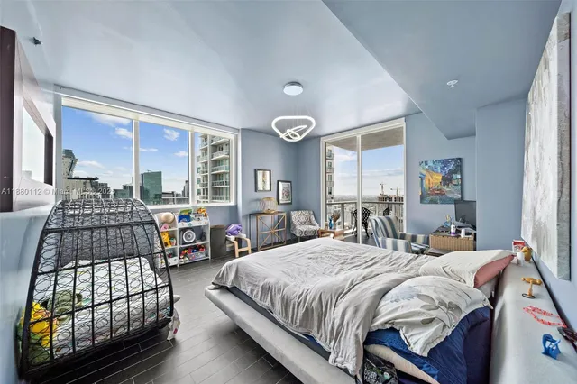 a bedroom with bed a mirror and a window