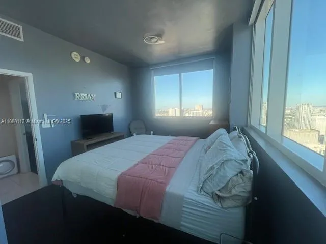 a bedroom with a bed and a tv