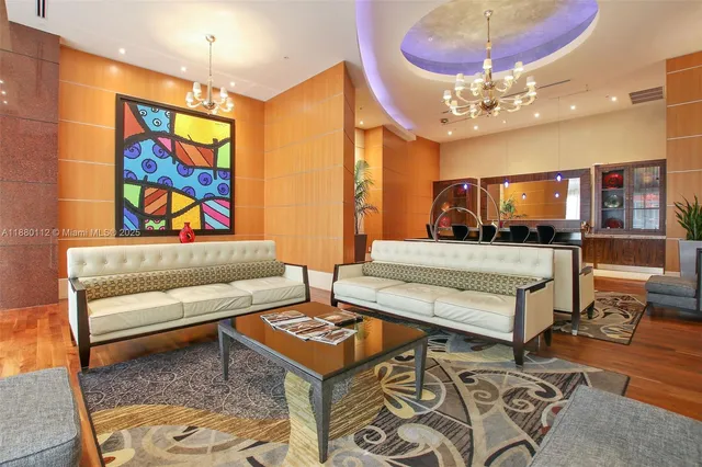 a living room with furniture and a chandelier