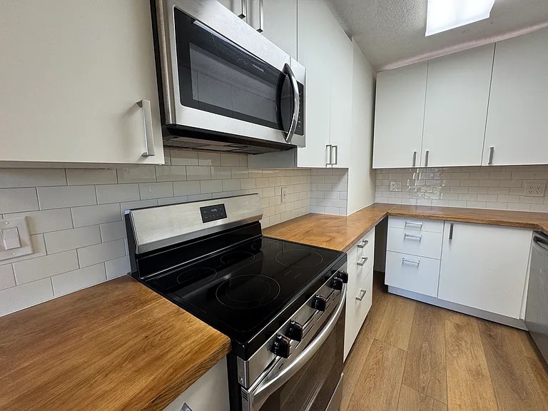 a kitchen with stainless steel appliances a stove microwave and cabinets