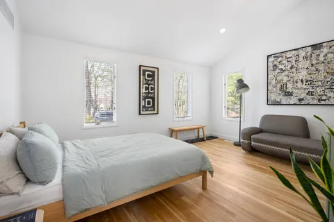 a bedroom with a bed and wooden floor