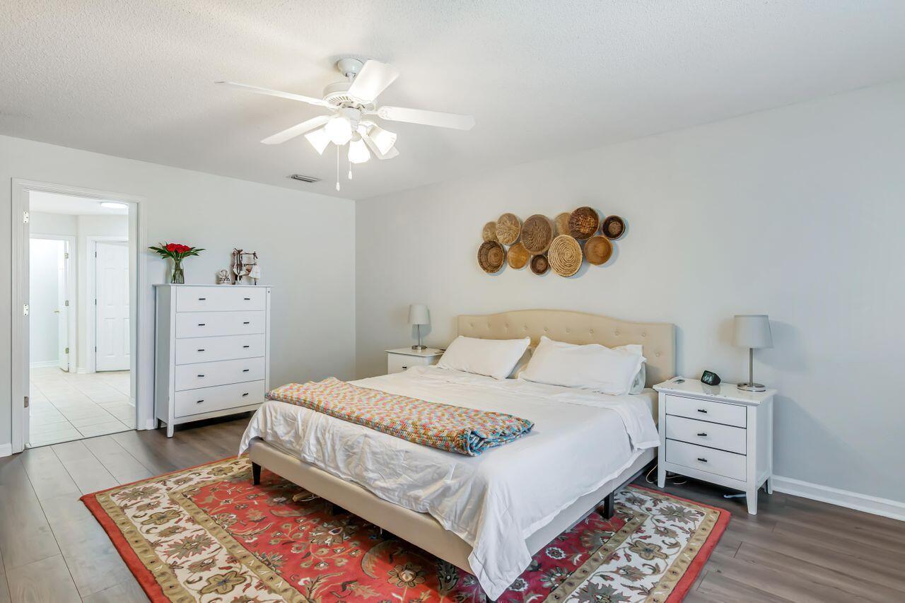 6830 Fernandina Road Navarre, FL 32566 - Photo 18 of 37 a bedroom with a bed and a chandelier