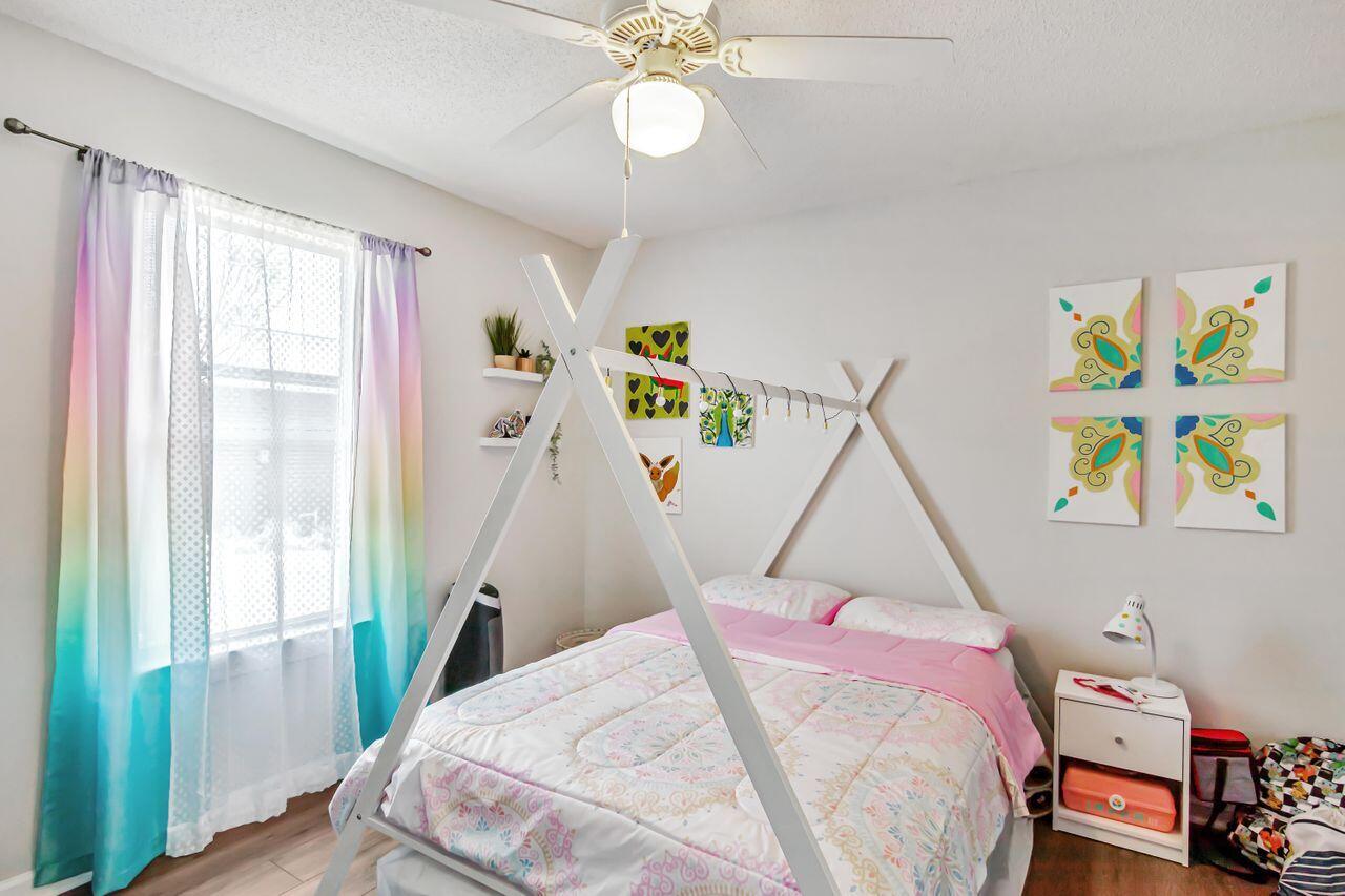 6830 Fernandina Road Navarre, FL 32566 - Photo 25 of 37 a bedroom with a bed and a chandelier