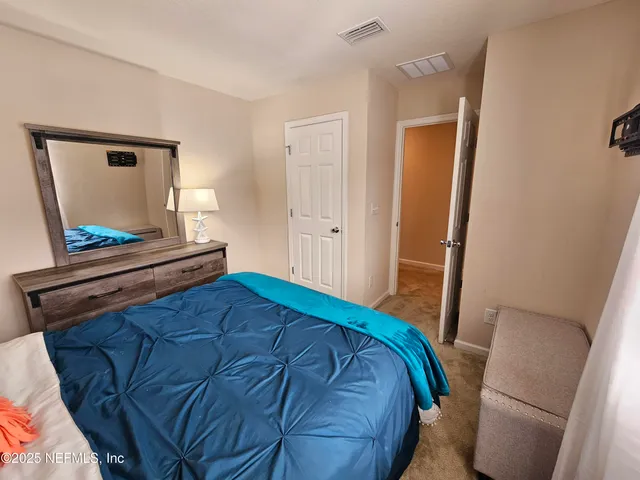 a view of a house with a yard and a large tree