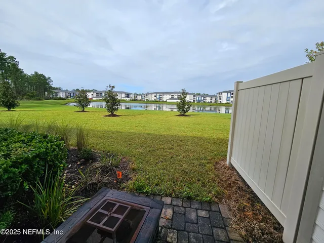 a view of a wrought iron fences with large trees