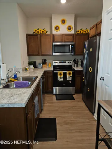 a kitchen with stainless steel appliances granite countertop a stove refrigerator and a microwave oven