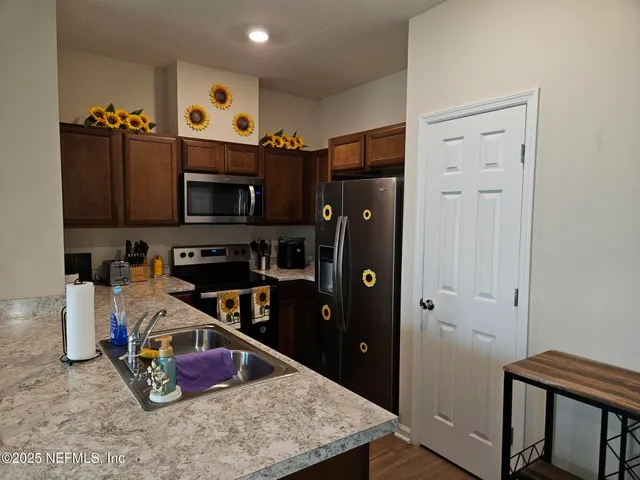 a kitchen with stainless steel appliances granite countertop a refrigerator and a stove top oven