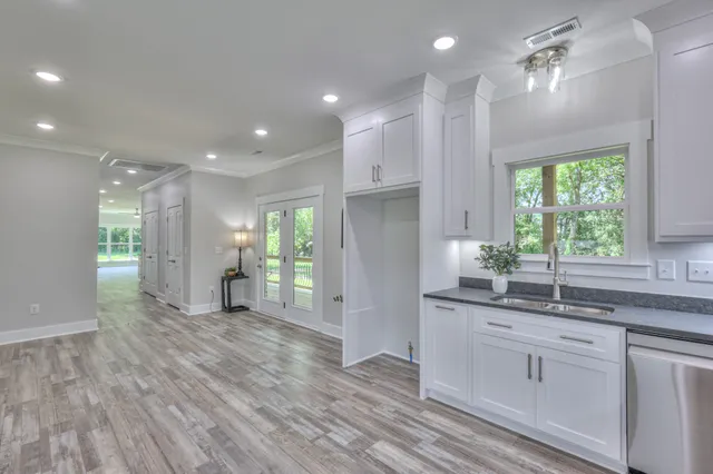 an empty room with wooden floor ceiling fan and windows