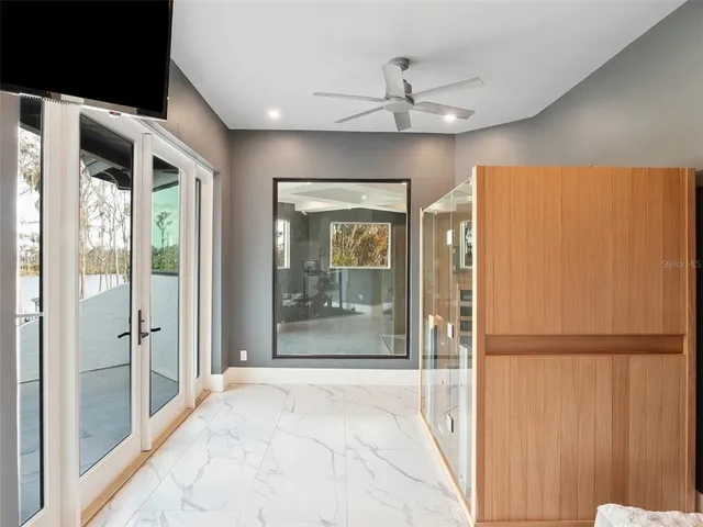 a living room with furniture a flat screen tv and a floor to ceiling window