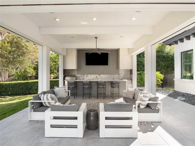 a view of a house with a big yard potted plants and large tree
