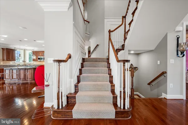 a kitchen with stainless steel appliances granite countertop a stove oven a dining table and chairs with wooden floor