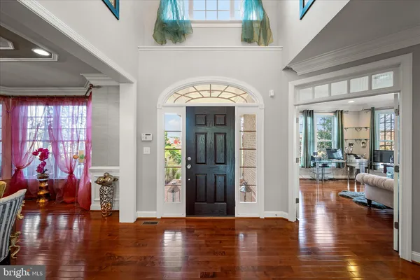 a view of a dining room with furniture a chandelier and wooden floor