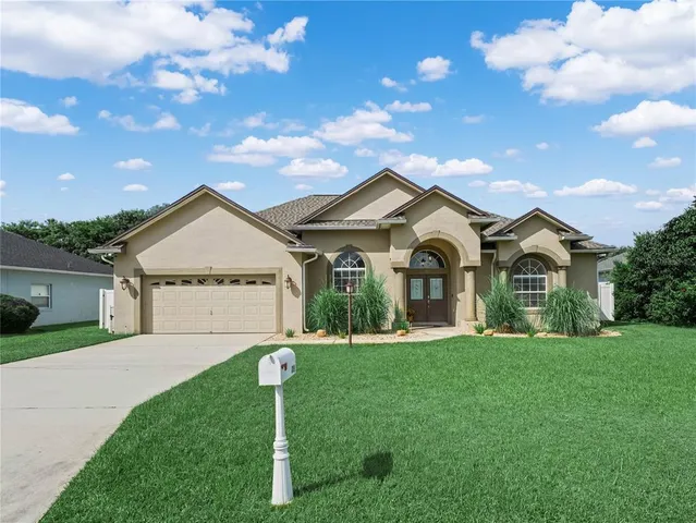 a front view of a house with a yard and garage