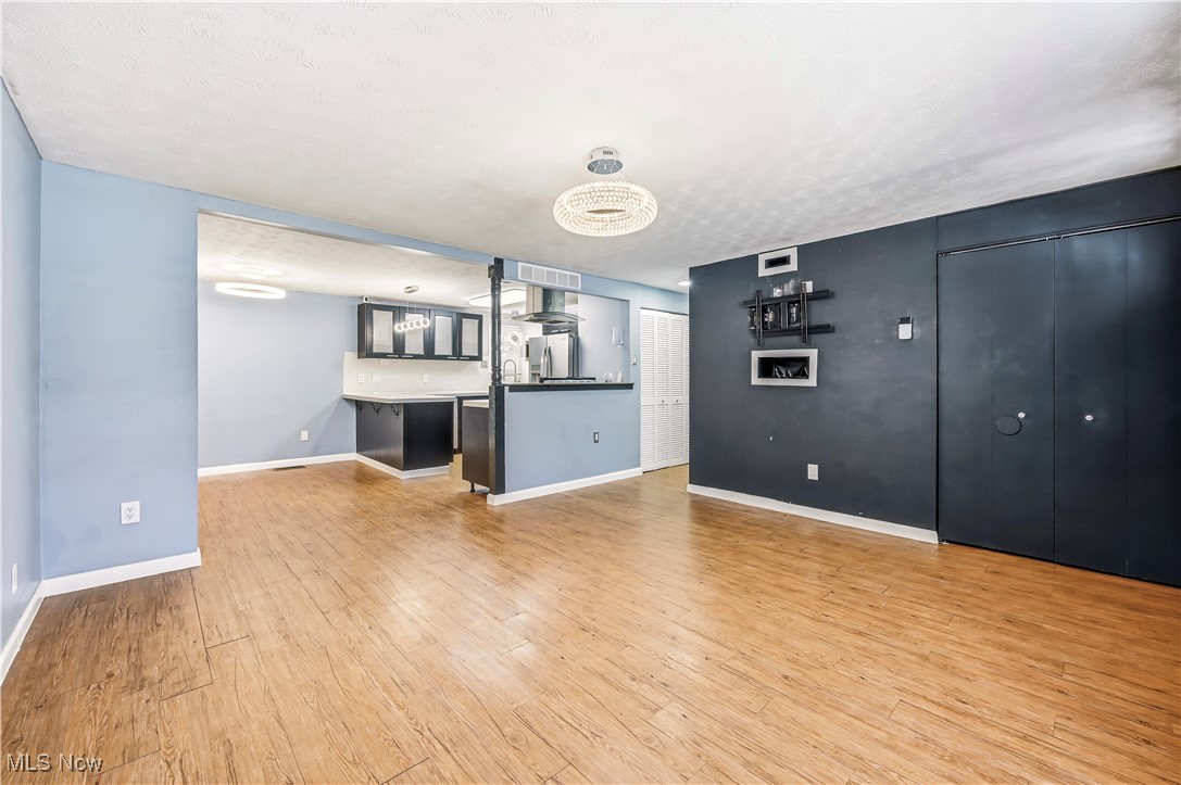 245 North Road Niles, OH 44446 - Photo 9 of 45 Unfurnished living room with light wood-style flooring and a chandelier