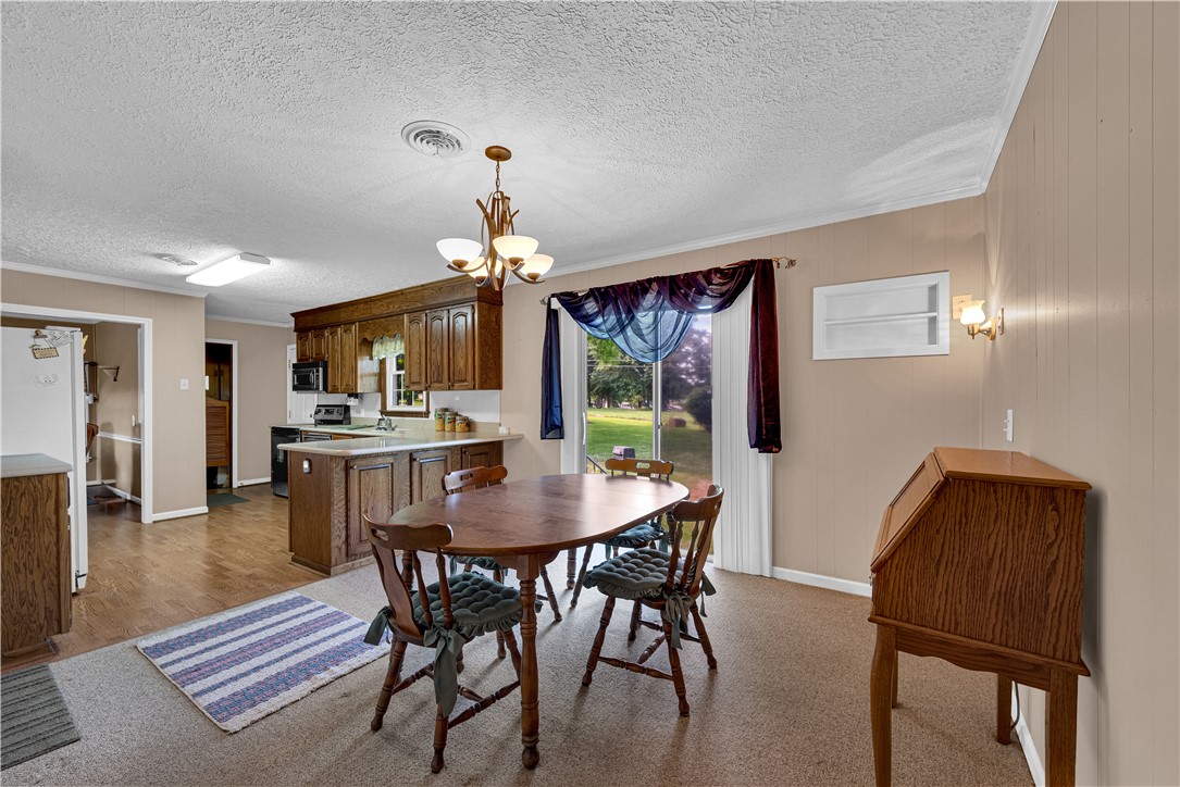 307 Calhoun Road Belton, SC 29627 - Photo 19 of 30 A well-lit eat-in kitchen with a kitchen island and views to the verdant yard beyond.