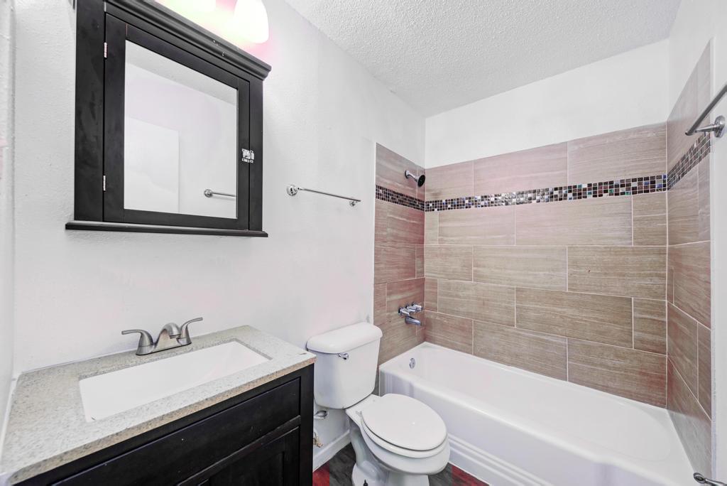2401 Manor Road, Unit 133 Austin, TX 78722 - Photo 18 of 20 A well-appointed bath features a tiled shower surround and a practical vanity.